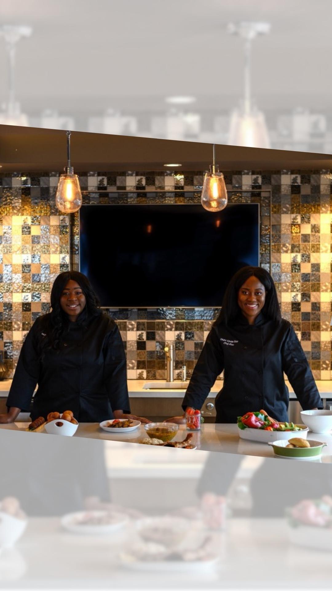 two women dressed in black in a gourmet kitchen