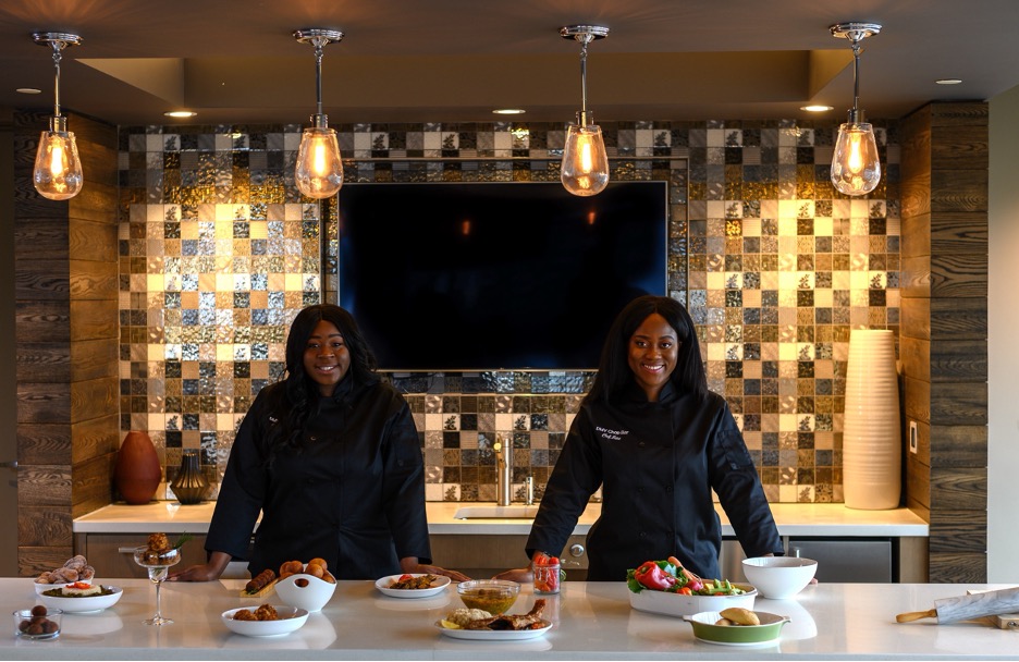 two women dressed in black in a gourmet kitchen